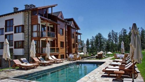 uma casa com piscina ao lado de um edifício em Spacious penthouse chalet apartment in Pirin Golf and Country Club em Razlog