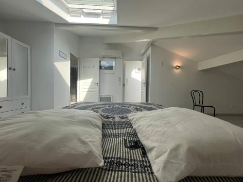 une chambre avec un lit avec des draps blancs et un tapis dans l'établissement Appartement T3 climatisé avec terrasse à La Ciotat – Idéal pour 4-5 personnes, proche du Vieux Port - FR-1-770-4, à La Ciotat