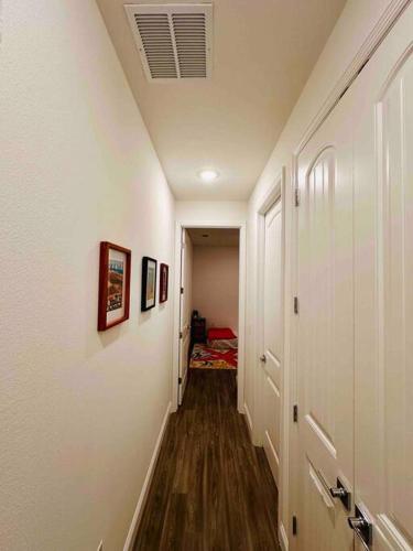 a hallway with white walls and wood floors and a hallway with a hallway at Luxury King Suite, 3BR 2BA, Beach Vibe, Top-Tier Amenities, Prime location in Palm Coast