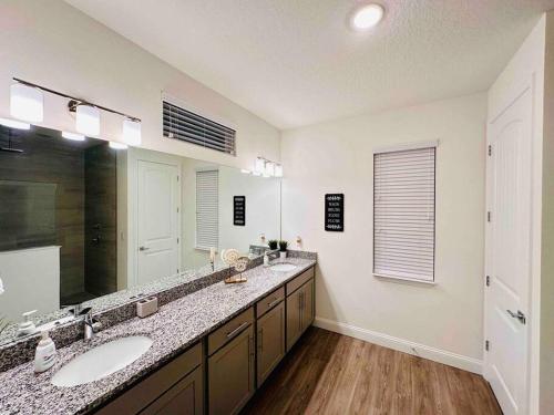 a bathroom with two sinks and a large mirror at Palm Coast Paradise : Cozy 3BR Vacation Retreat in Palm Coast