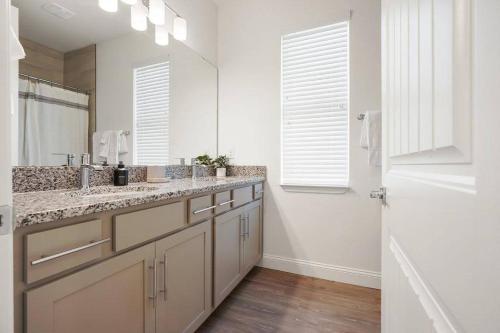 a bathroom with two sinks and a large mirror at Luxury King Suite, 3BR 2BA, Beach Vibe, Top-Tier Amenities, Prime location in Palm Coast