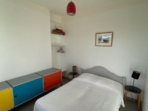 - une chambre avec un lit et une commode colorée dans l'établissement Appartement Cosy à 10m de la Plage - Tout Équipé, Parking Gratuit, 4 Pers. - FR-1-770-12, à La Ciotat