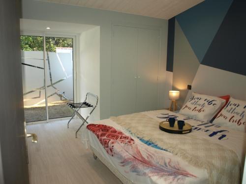 une chambre avec un lit avec un plateau dessus dans l'établissement Charmante maison rénovée en lisière de forêt, 600m de la plage, 2 jardins clos, confort moderne - FR-1-323-371, à Saint-Jean-de-Monts