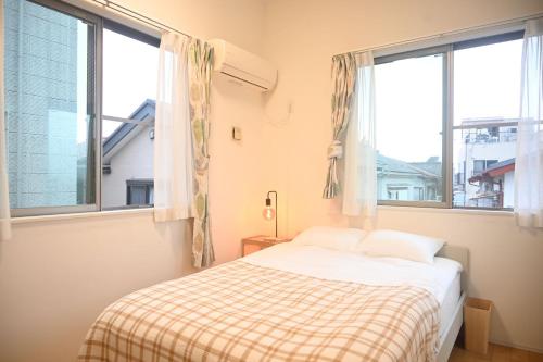 a bedroom with a bed and two large windows at YIAN-Nishiikebukuro in Tokyo