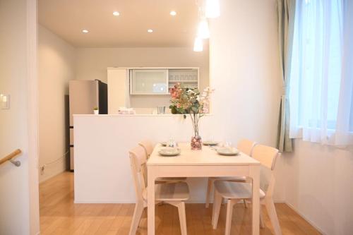 a kitchen and dining room with a table and chairs at Mi-Villa Pure Gray in Tokyo