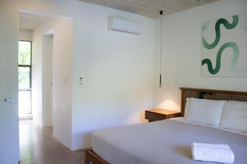 a bedroom with a white bed with a towel on it at D'Palm Villas in Puntarenas