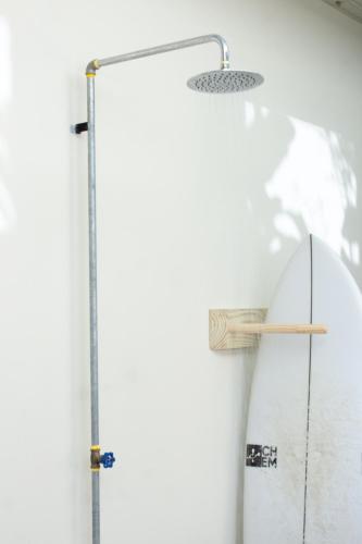 a shower with a wooden wand on a wall at D'Palm Villas in Puntarenas