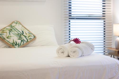 two rolls of towels sitting on top of a bed at D'Palm Villas in Puntarenas