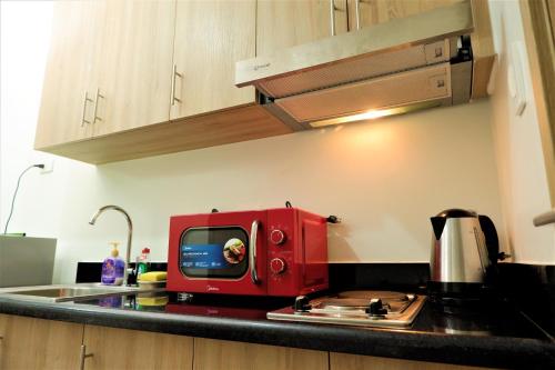 a red toaster sitting on top of a kitchen counter at Shore Residences MOA Dynastel Staycation in Manila