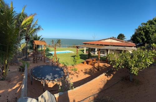 une arrière-cour avec une piscine, un pavillon et une maison dans l'établissement Casa de praia Aurora, à Icapuí