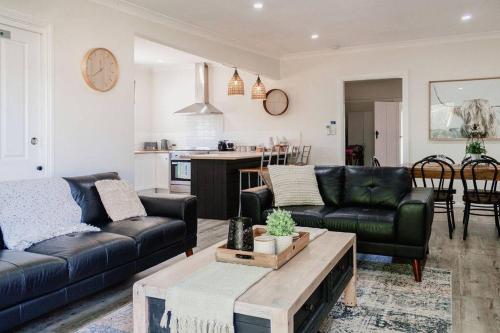 a living room with two couches and a table at Live in the Heart of Mudgee at Fairbairn Cottage in Mudgee