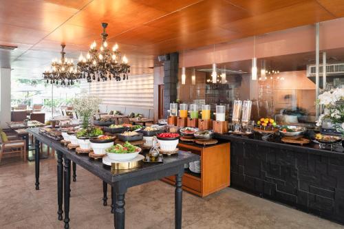 a buffet line with bowls of food on a table at Woodlands Suites Serviced Residences - SHA Extra Plus in Pattaya North