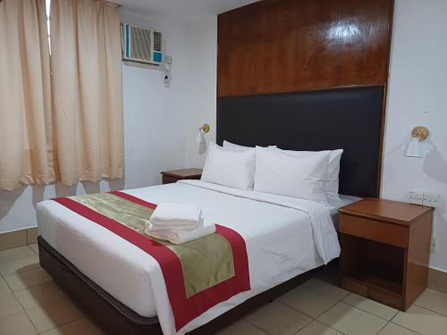 Hotel Seri Putra في كوالالمبور: غرفة نوم بسرير كبير مع اللوح الخشبي