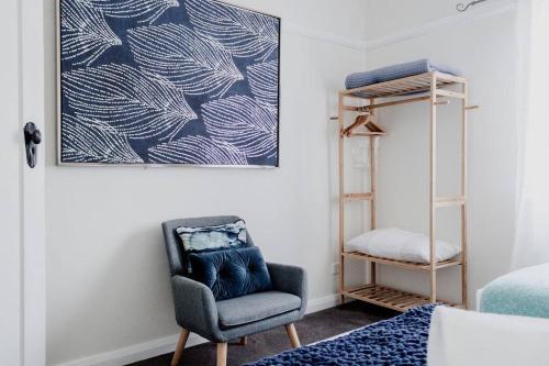 a bedroom with a chair and a picture on the wall at Live in the Heart of Mudgee at Fairbairn Cottage in Mudgee