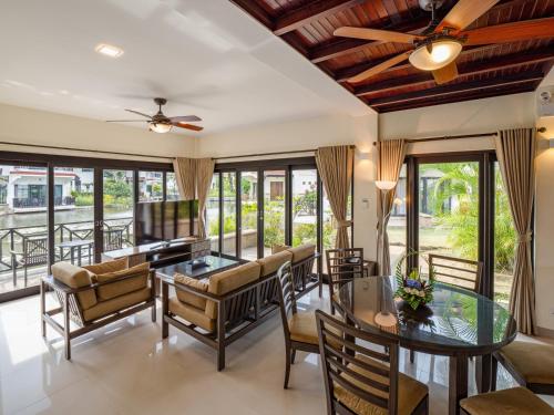 a living room with a table and chairs and a couch at Banyu Biru Villa in Lagoi