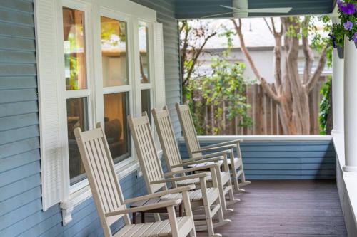 - une rangée de chaises assises sur la terrasse couverte d'une maison dans l'établissement Grape Escape Inn & Suites, à Lodi