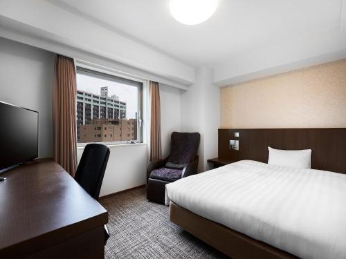 a hotel room with a bed and a window at Daiwa Roynet Hotel Kawasaki in Kawasaki