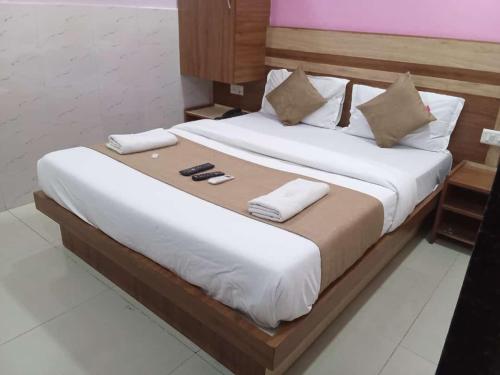 - une chambre avec un grand lit et des draps blancs dans l'établissement Hotel Shree Krishna, à Ahmedabad
