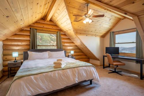 a bedroom with a bed and a desk in a room at 4 Kings Log Cabin 150 Acres Spectacular Views in Three Rivers
