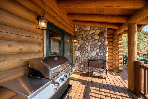 an outdoor kitchen with a stove on a deck at 4 Kings Log Cabin 150 Acres Spectacular Views in Three Rivers
