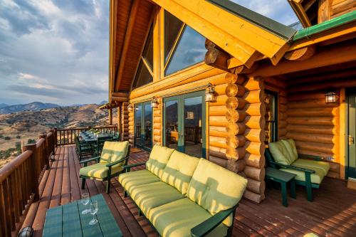 eine Veranda mit Stühlen und einer Couch auf einer Hütte in der Unterkunft 4 Kings Log Cabin 150 Acres Spectacular Views in Three Rivers