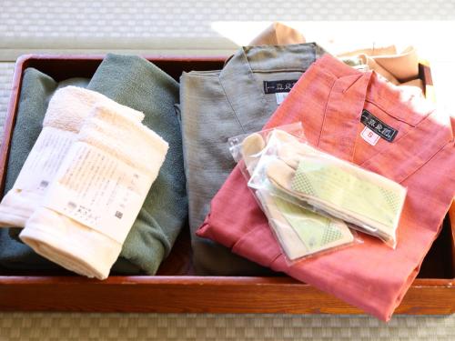 a suitcase filled with different colored shirts and ties at Hotel Asafuji in Fujikawaguchiko