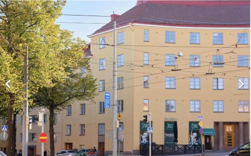 un grande edificio giallo sul lato di una strada di Cozy City Studio by tram and bus stops a Helsinki