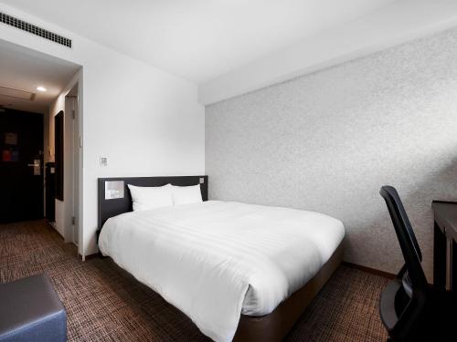 a bedroom with a large white bed in it at Daiwa Roynet Hotel Kawasaki in Kawasaki