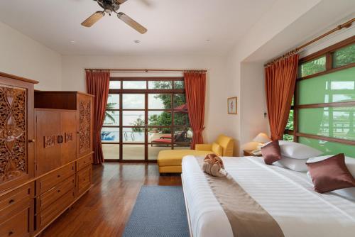 a bedroom with a bed and a large window at Indra Maya Pool Villas in Lagoi