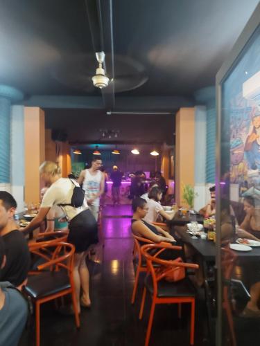 a group of people sitting at tables in a restaurant at Saigon Rooftops Hostel in Ho Chi Minh City