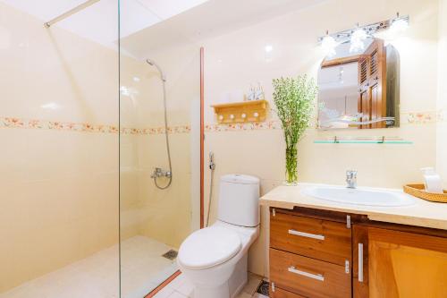 uma casa de banho com um chuveiro, um WC e um lavatório. em Pasteur Home 3 em Ho Chi Minh