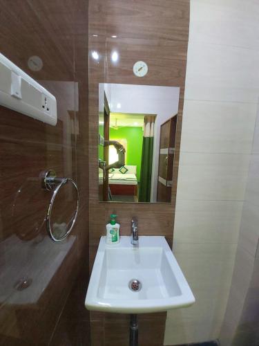 a bathroom with a white sink and a mirror at KSR GRAND in Srikalahasti