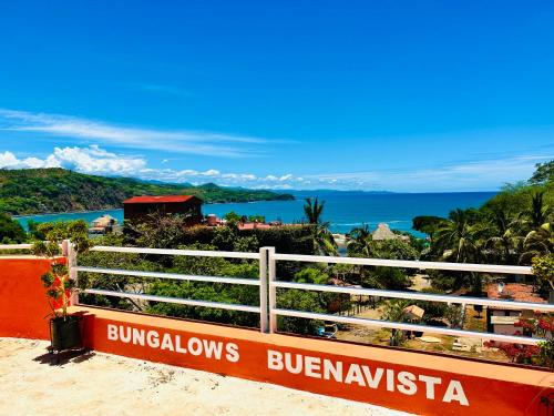 a sign on the side of a beach with the ocean at Bungalows BuenaVista in Chacala