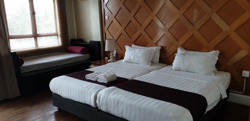 a bedroom with a large bed with a wooden headboard at Lagoon Residence @ Langkawi in Pantai Cenang