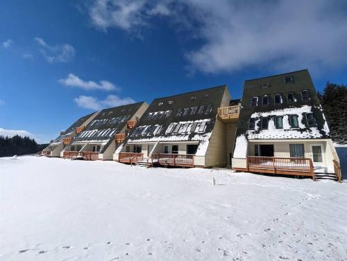 a large building in the snow with snow on the ground at Evergreen Escape At Snowshoe in Snowshoe