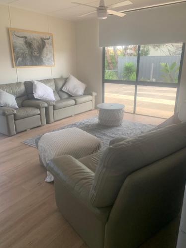 a living room with a couch and a table at Investigator Beach Breeze Apartments U1 in Kingscote