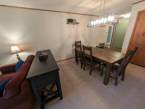 a living room with a table and a couch at Evergreen Escape At Snowshoe in Snowshoe