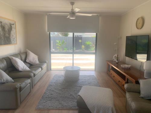 a living room with a couch and a tv at Investigator Beach Breeze Apartments U1 in Kingscote