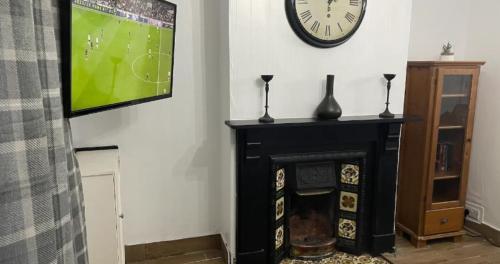 a living room with a tv and a fireplace at Contractors Grove 2 Bed House Town Centre Location in Wellingborough