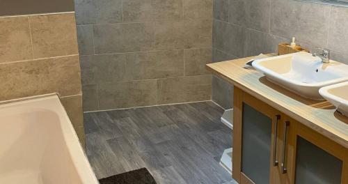 a bathroom with a sink and a bath tub at Contractors Grove 2 Bed House Town Centre Location in Wellingborough