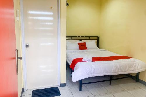 a small bedroom with a bed with a red pillow at RedDoorz @ Balaraja Centre Plaza in Tangerang
