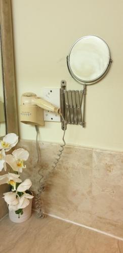 a mirror and a hair dryer on a wall at Lagoon Residence @ Langkawi in Pantai Cenang