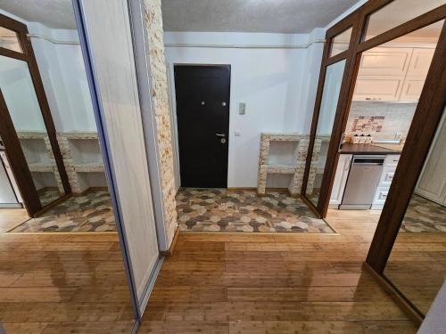 a view of a hallway with a door and mirror at Apartament 3 camere plus living, 2 bai, modern in Craiova