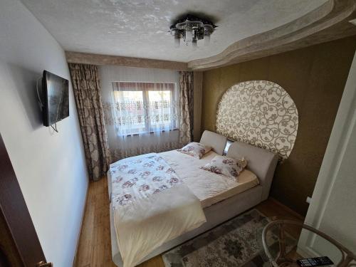 a small bedroom with a bed and a window at Apartament 3 camere plus living, 2 bai, modern in Craiova