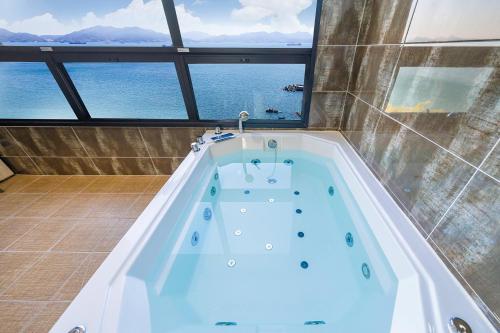 eine Whirlpool-Badewanne mit Meerblick in der Unterkunft Le Paradis Ocen view Spa Pension in Yeosu