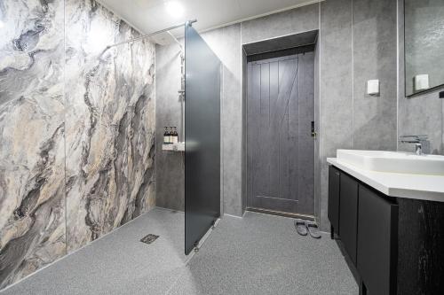 a bathroom with a shower and a sink and a shower stall at Le Paradis Ocen view Spa Pension in Yeosu