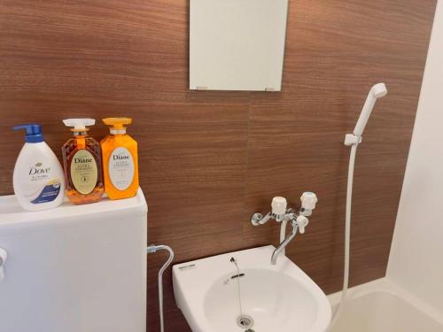 ein Badezimmer mit einem Waschbecken und zwei Flaschen Seife in der Unterkunft 100m from nearest bus stop/8 mins to Ikebukuro sta in Tokio