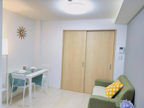 a living room with a couch and a table and a door at 100m from nearest bus stop/8 mins to Ikebukuro sta in Tokyo