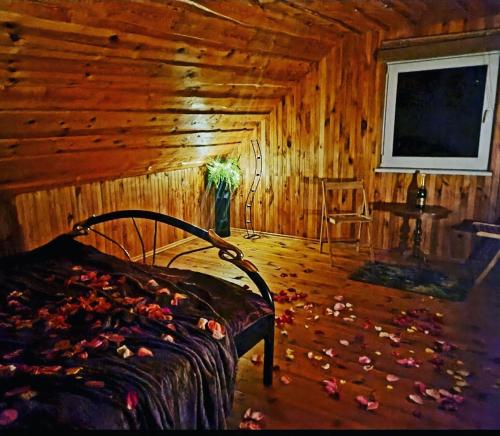 ein Schlafzimmer mit einem Bett in einem Holzzimmer in der Unterkunft Gintarinė Sodyba in Pilypai