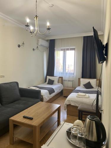 een woonkamer met 2 bedden en een bank bij V.MOD Hotel in Jerevan